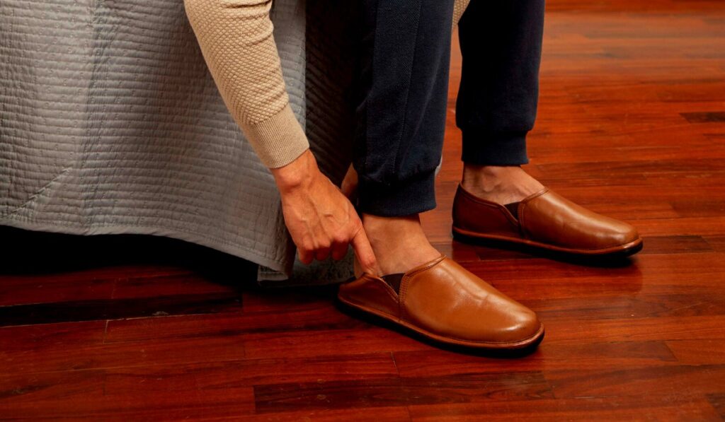 Hombre ajustandose sus zapatos de cuero