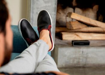 Persona con pies levantados sobre el sofa