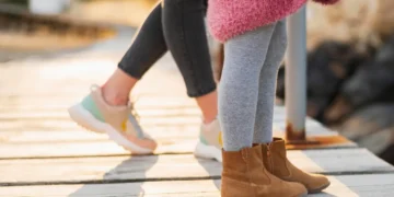 Niña con su madre en invierno mostrando los botines resistentes para niños activos